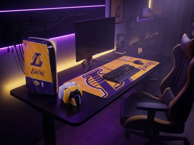 A Los Angeles Lakers desk mat, PS5 skin and controller dock on a gaming desk